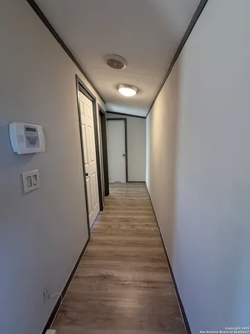 an empty room with wooden floor ceiling fan and windows