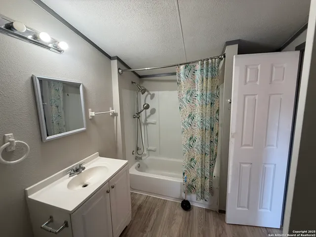 a view of a hallway with wooden floor and a toilet