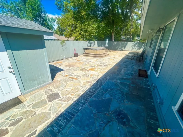 a view of a house with backyard and sitting area