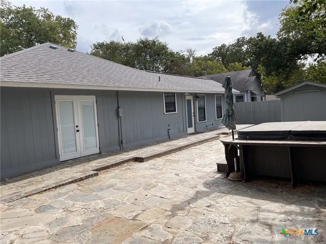 a view of a patio with table and chairs with wooden fence and plants