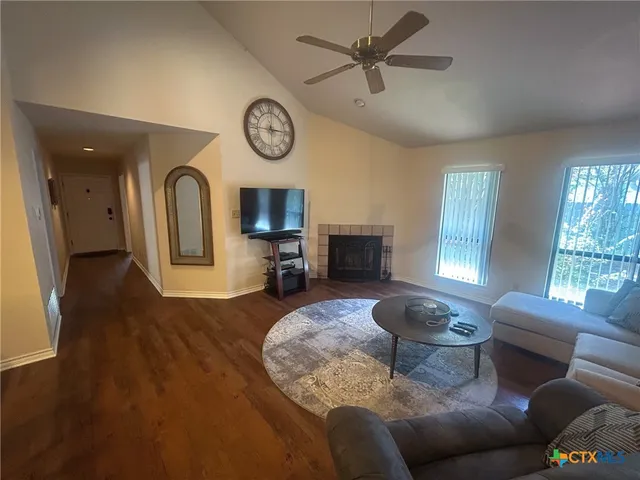 a living room with furniture a fireplace and a window