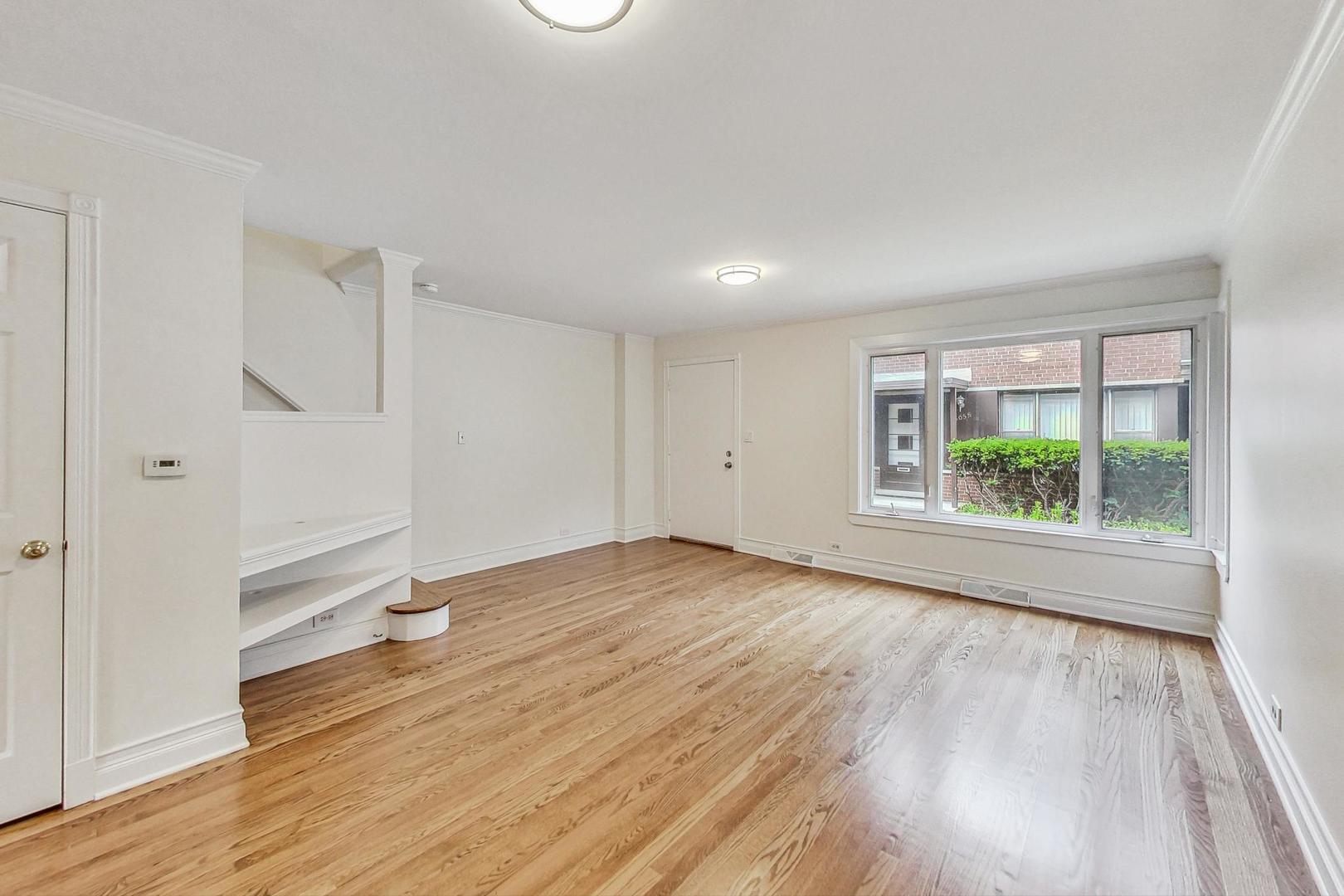 503 Ridge Road, Unit 503 Wilmette, IL 60091 - Photo 4 of 19 an empty room with wooden floor and windows
