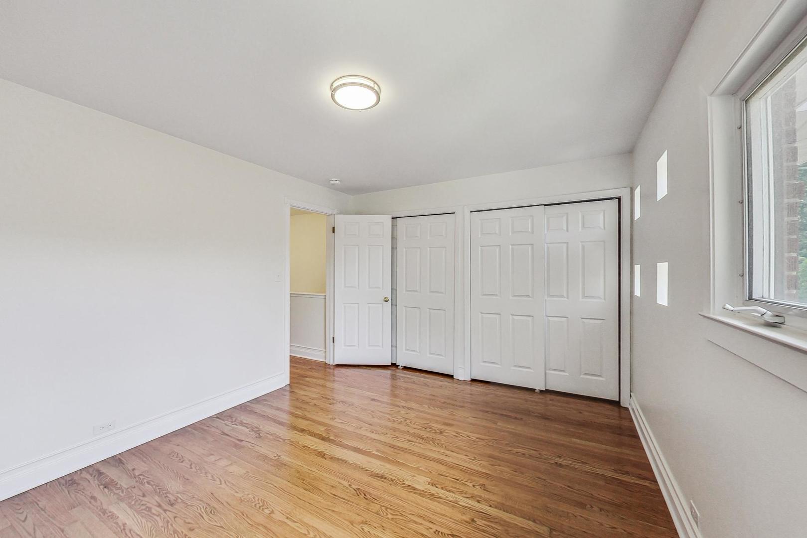 503 Ridge Road, Unit 503 Wilmette, IL 60091 - Photo 8 of 19 a view of an empty room with wooden floor and a window
