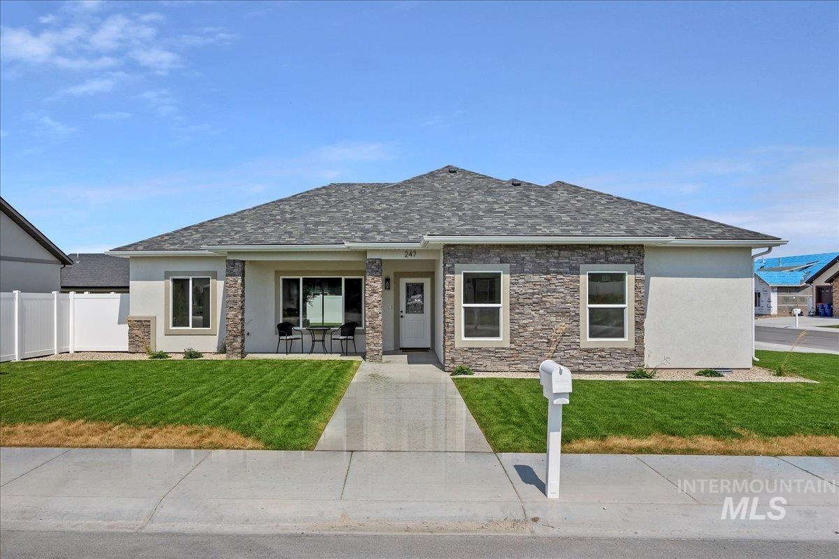 View of front of home with stucco siding, covered porch, and stone siding