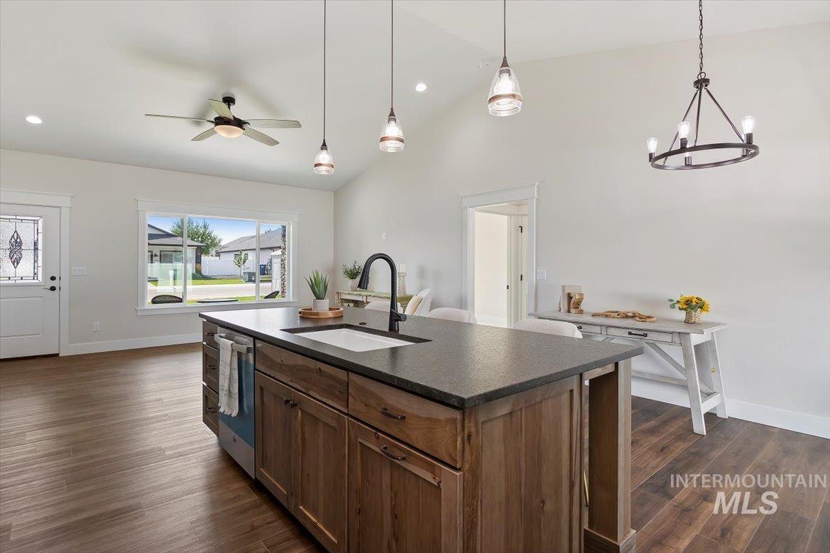 247 Sandi Road Twin Falls, ID 83301 - Photo 12 of 34 Kitchen featuring a kitchen island with sink, vaulted ceiling, dark wood-style flooring, hanging light fixtures, and a ceiling fan