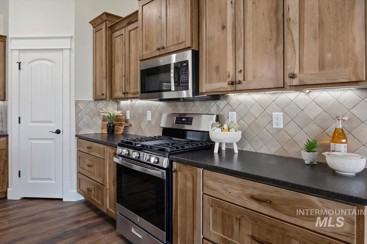 247 Sandi Road Twin Falls, ID 83301 - Photo 10 of 34 Kitchen with appliances with stainless steel finishes, decorative backsplash, and dark wood-style floors