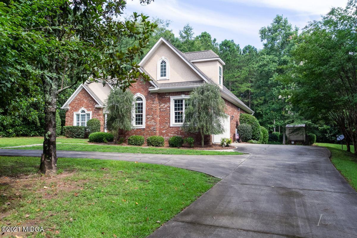 a front view of a house with a yard and green space