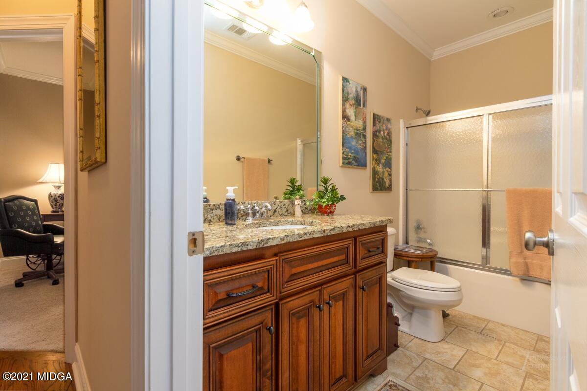 7109 Colaparchee Road Macon, GA 31220 - Photo 27 of 34 a bathroom with a granite countertop sink a toilet and a mirror