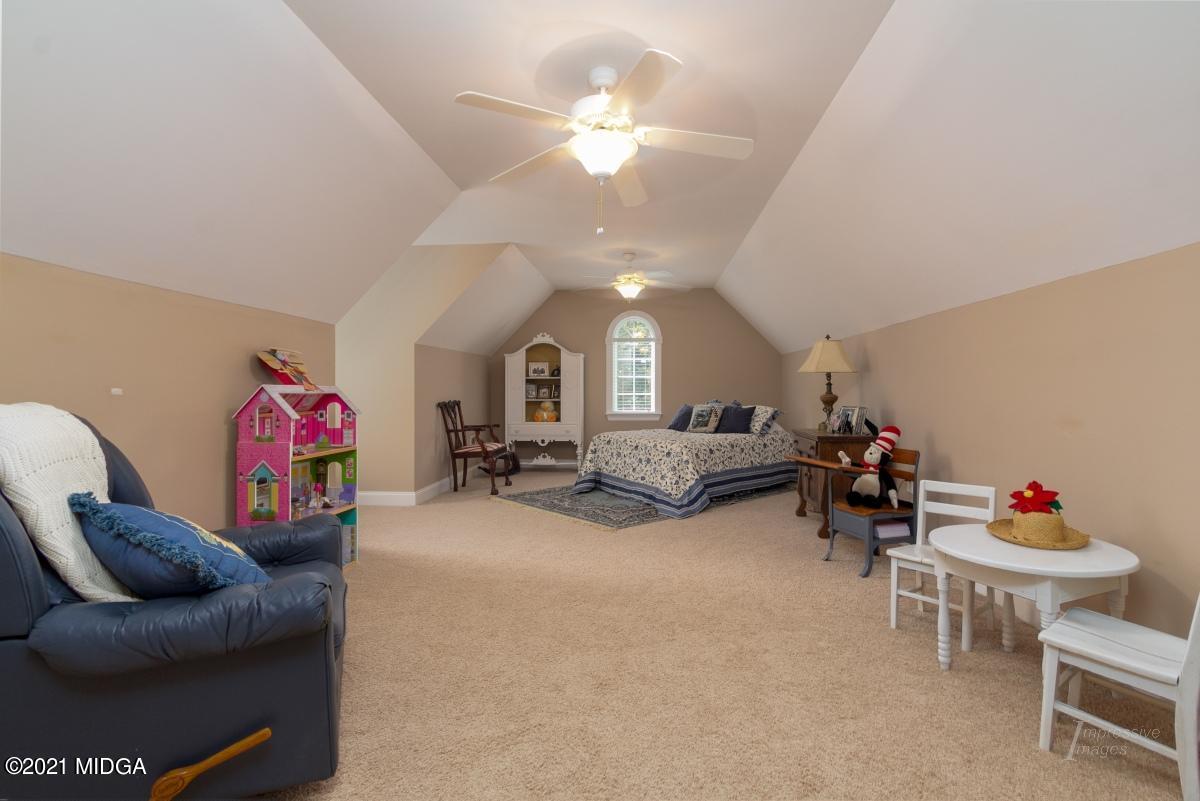 7109 Colaparchee Road Macon, GA 31220 - Photo 28 of 34 a living room with furniture and a chandelier