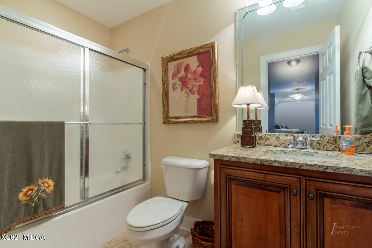 7109 Colaparchee Road Macon, GA 31220 - Photo 29 of 34 a bathroom with a granite countertop toilet a sink and a mirror