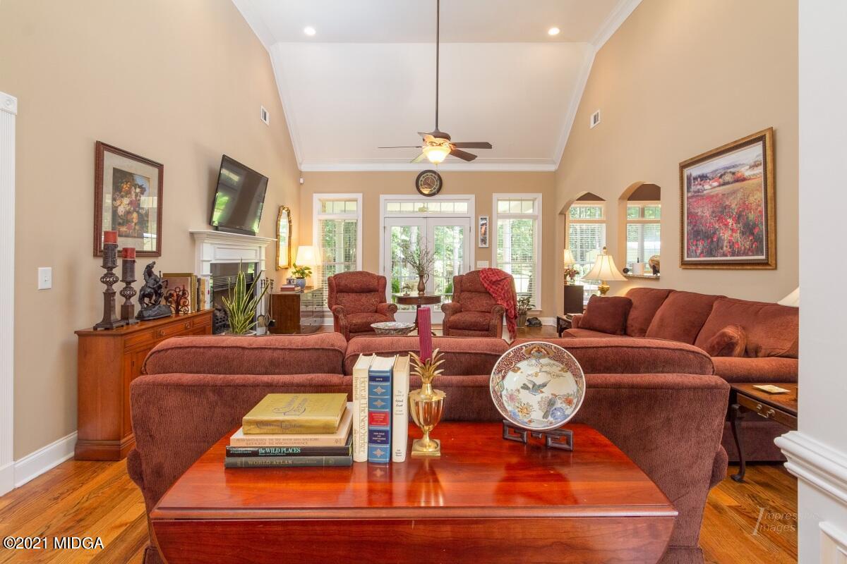 7109 Colaparchee Road Macon, GA 31220 - Photo 7 of 34 a living room with furniture a clock and a ceiling fan