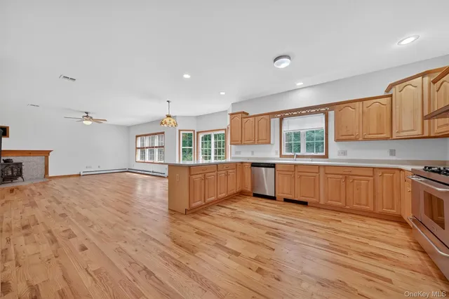 a large kitchen with stainless steel appliances granite countertop a large counter top and wooden floors