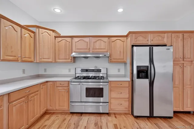 a kitchen with stainless steel appliances granite countertop a refrigerator sink and cabinets