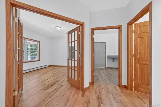 an empty room with wooden floor and a bathroom