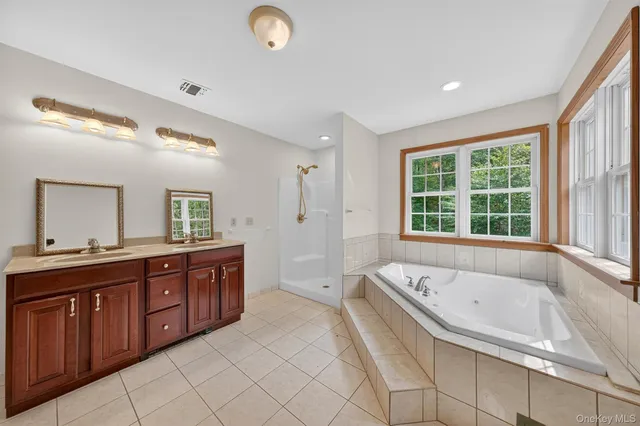 a spacious bathroom with a granite countertop tub sink and mirror