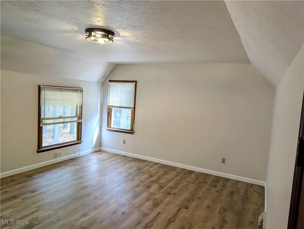 66565 Lake Ridge Road Lore City, OH 43755 - Photo 12 of 26 Upstairs Master bedroom, light wood-type flooring, and a textured ceiling