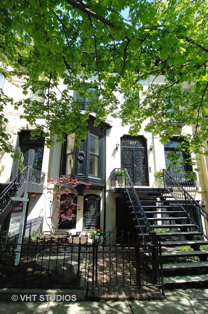 a view of house with yard outdoor seating and covered with trees