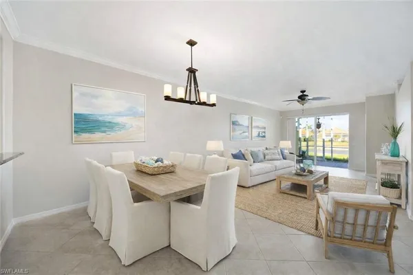 a living room with furniture a chandelier and a dining table