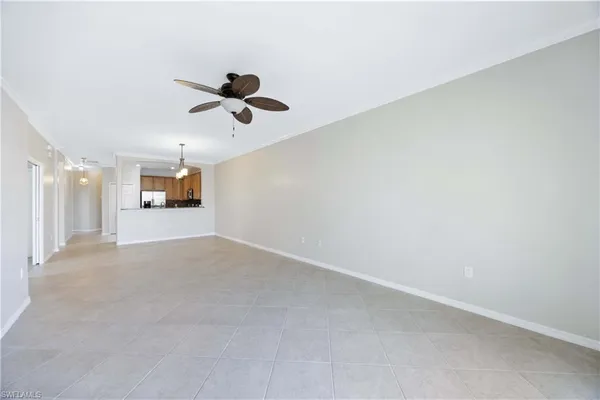 an empty room with wooden floor ceiling fan and windows