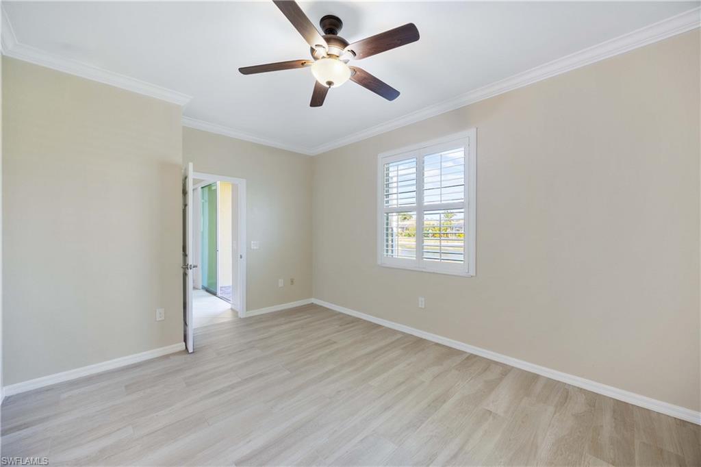 14488 Grapevine Drive Naples, FL 34114 - Photo 14 of 36 an empty room with wooden floor ceiling fan and windows