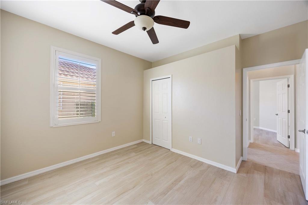 14488 Grapevine Drive Naples, FL 34114 - Photo 16 of 36 a view of an empty room with wooden floor and a window