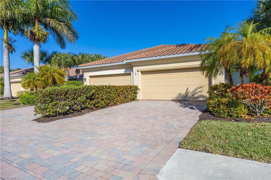 14488 Grapevine Drive Naples, FL 34114 - Photo 23 of 36 a front view of a house with a yard and a garage