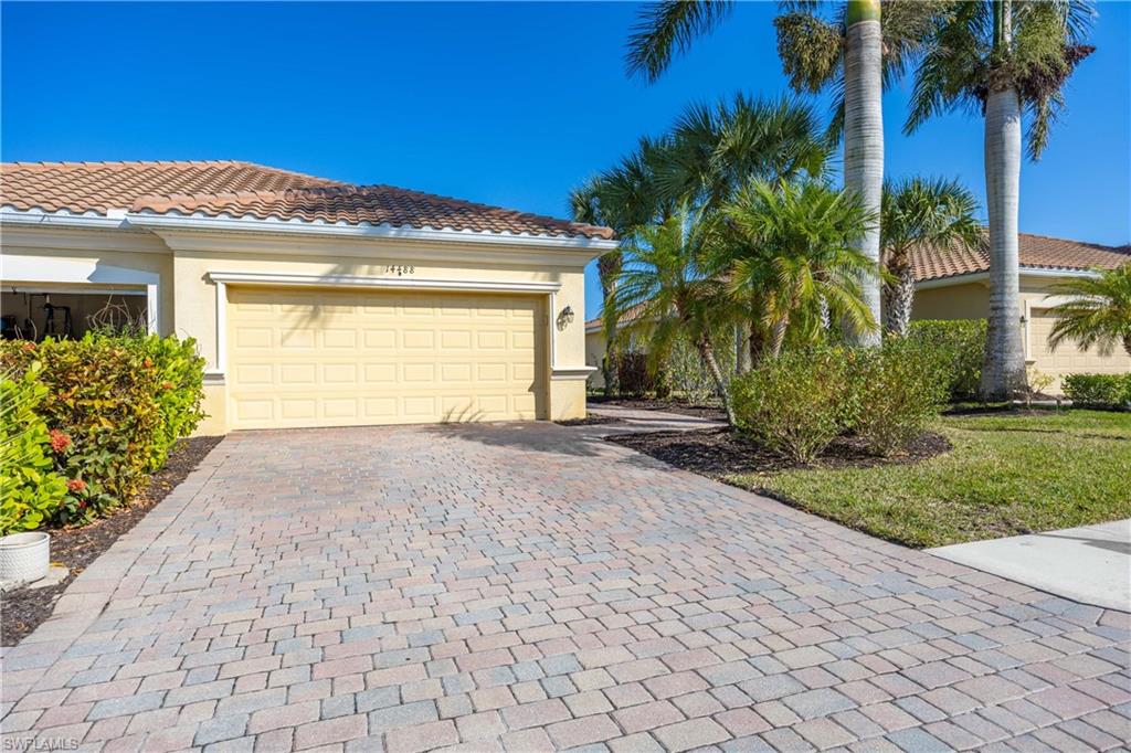 14488 Grapevine Drive Naples, FL 34114 - Photo 4 of 36 a view of a house with a small yard and a palm tree