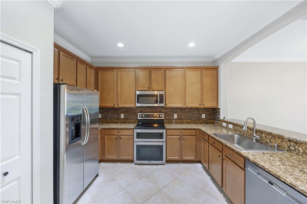 14488 Grapevine Drive Naples, FL 34114 - Photo 6 of 36 a kitchen with a sink stove and refrigerator