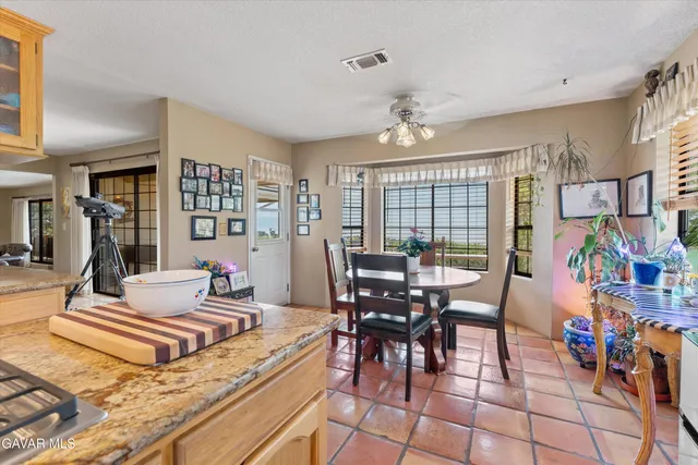 a large kitchen with stainless steel appliances granite countertop a large counter top a stove a chimney a sink and cabinets