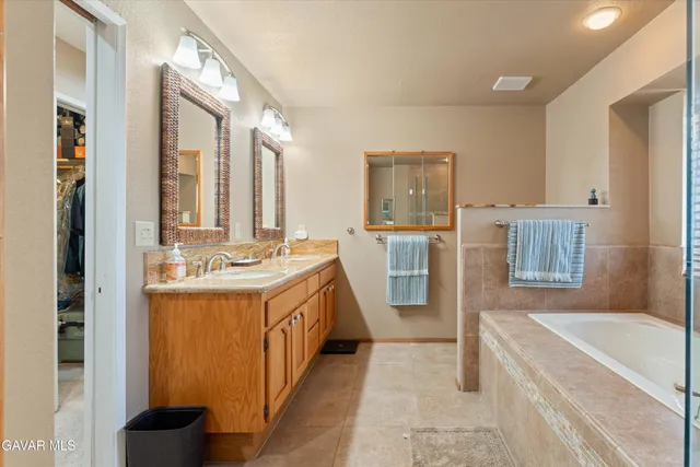 a bathroom with a granite countertop sink vanity mirror and toilet