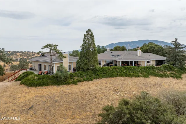 an aerial view of residential house with yard and mountain view in back