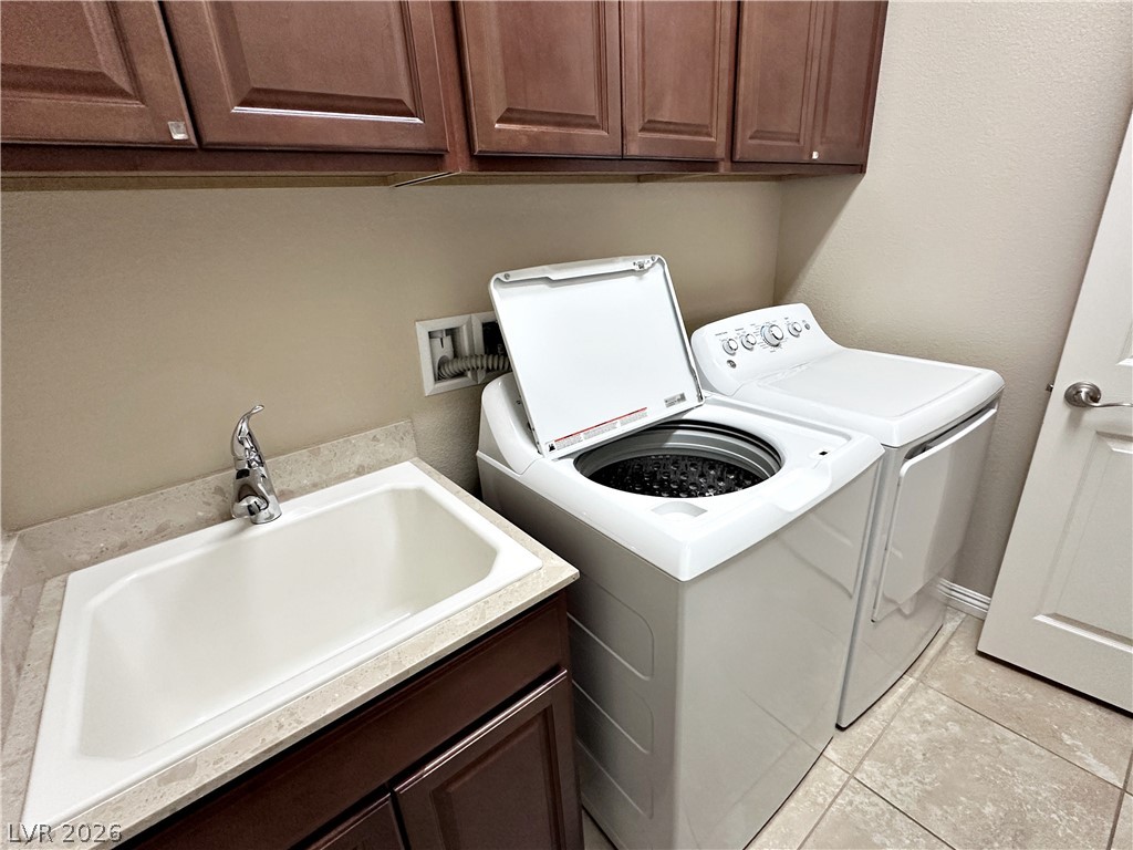 71 Newton Ridge Way Las Vegas, NV 89183 - Photo 39 of 40 Functional laundry room equipped with a convenient utility sink and ample cabinet storage.