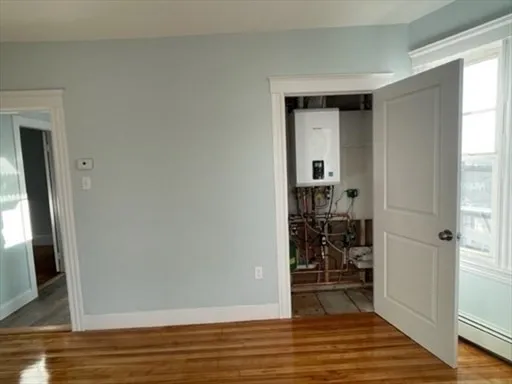 a view of empty room with wooden floor