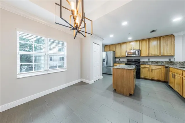 a kitchen with stainless steel appliances granite countertop a stove top oven a refrigerator a sink and a island