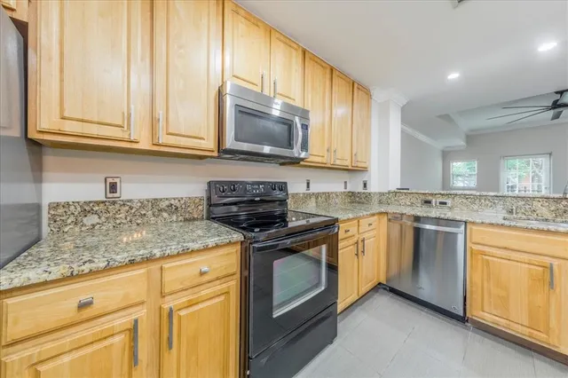 a kitchen with stainless steel appliances granite countertop a refrigerator and a stove top oven