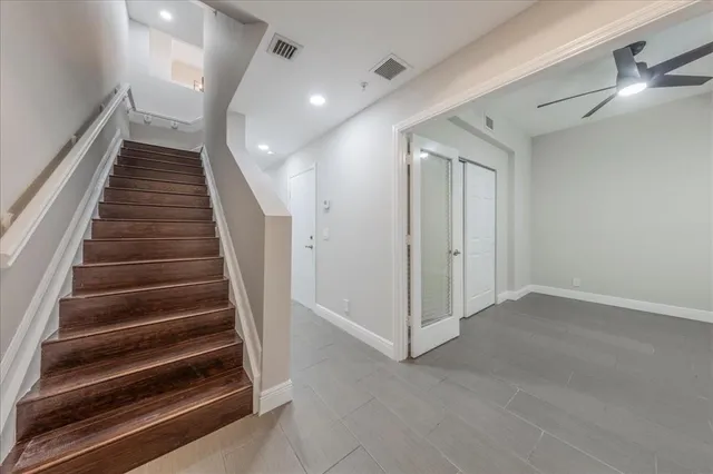 an empty room with a window and a fan