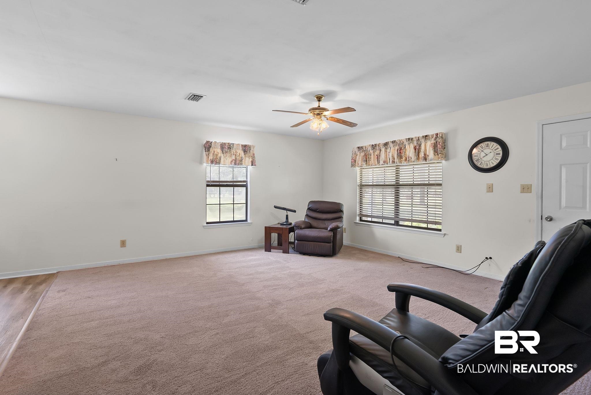 20540 Lacey Road Silverhill, AL 36576 - Photo 4 of 40 Spacious room featuring neutral carpeting, white walls, and a ceiling fan with integrated lighting