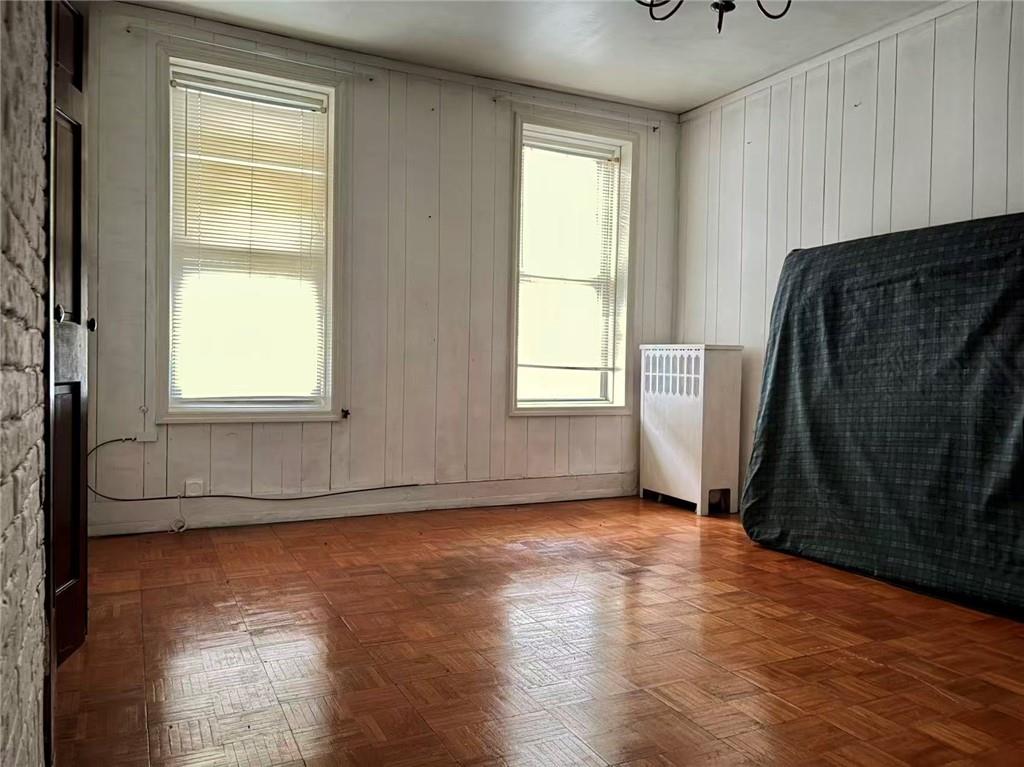 2276 78th Street Brooklyn, NY 11214 - Photo 4 of 16 a view of an empty room with wooden floor and a window