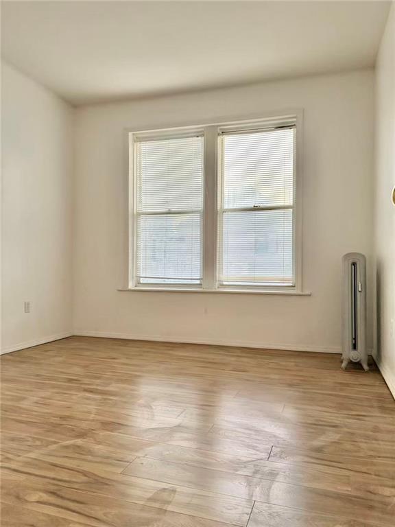 2276 78th Street Brooklyn, NY 11214 - Photo 6 of 16 a view of an empty room with wooden floor and a window