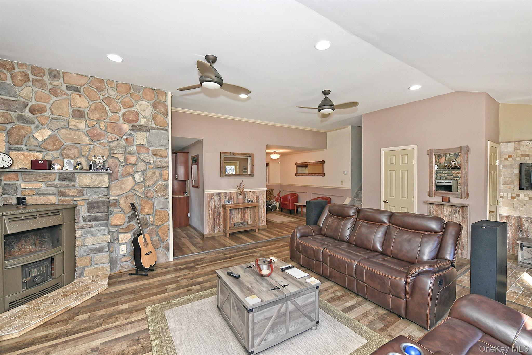 150 Hallock Landing Road Rocky Point, NY 11778 - Photo 11 of 36 Living area with a fireplace, wainscoting, wood finished floors, a ceiling fan, and recessed lighting