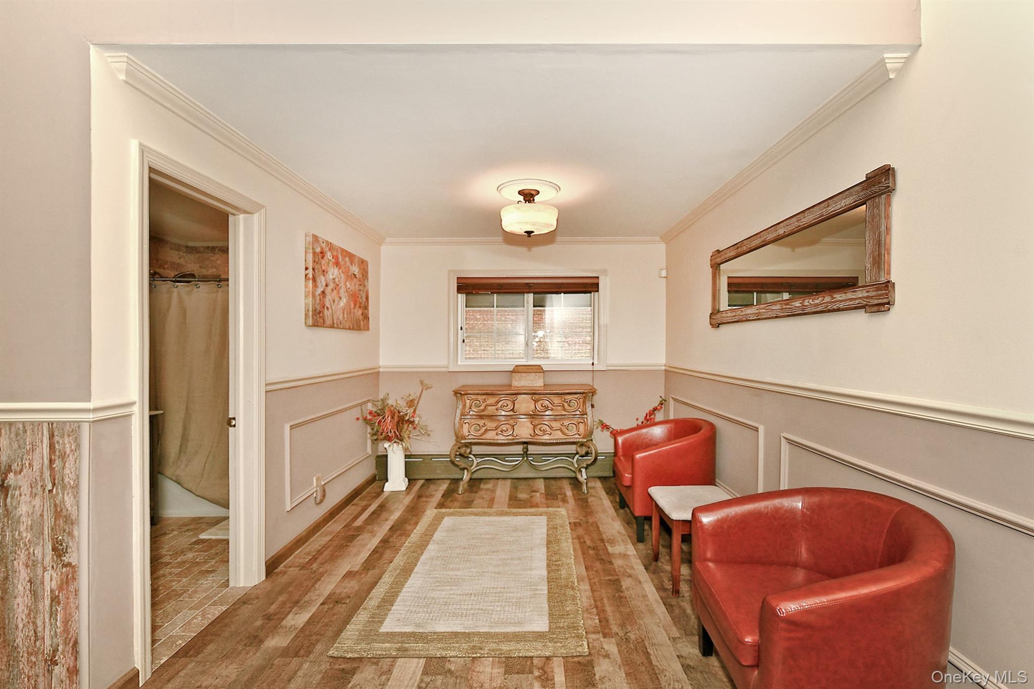 150 Hallock Landing Road Rocky Point, NY 11778 - Photo 17 of 36 Corridor featuring wainscoting, wood finished floors, a decorative wall, and crown molding