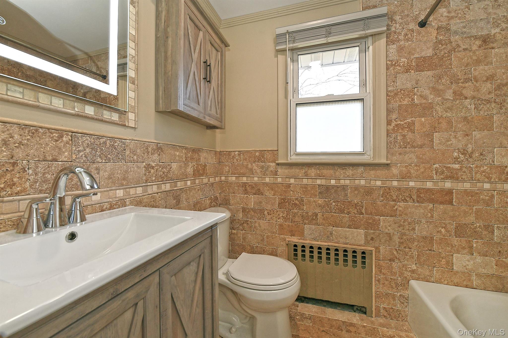 150 Hallock Landing Road Rocky Point, NY 11778 - Photo 20 of 36 Full bathroom with radiator, vanity, a bath, a shower with shower curtain, and tile walls