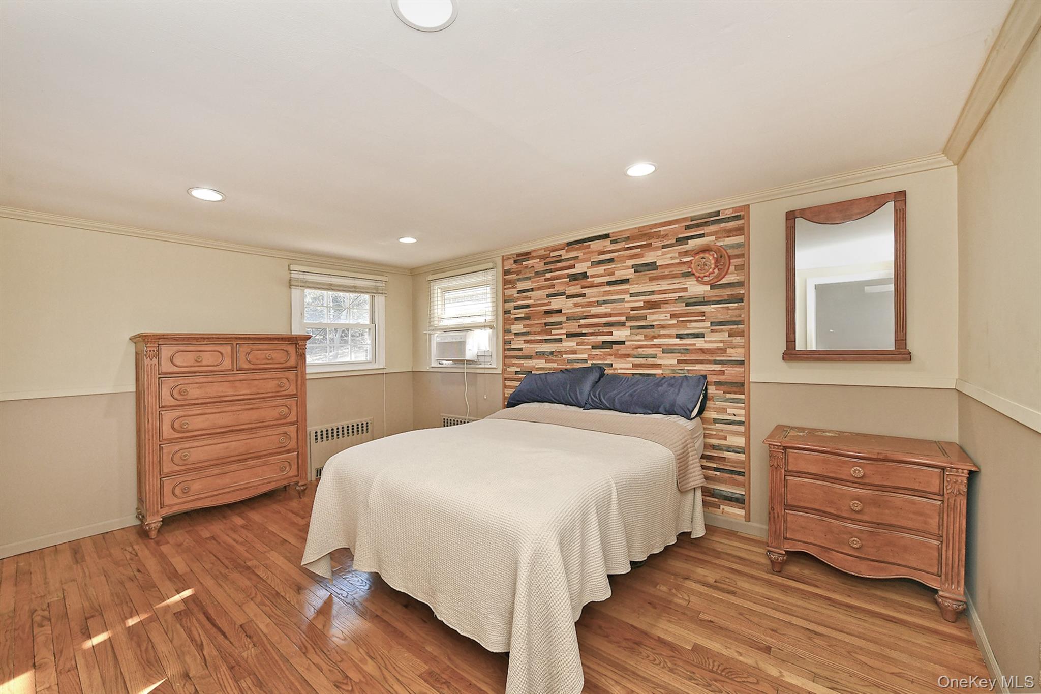 150 Hallock Landing Road Rocky Point, NY 11778 - Photo 21 of 36 Bedroom with ornamental molding, light wood finished floors, radiator, and recessed lighting