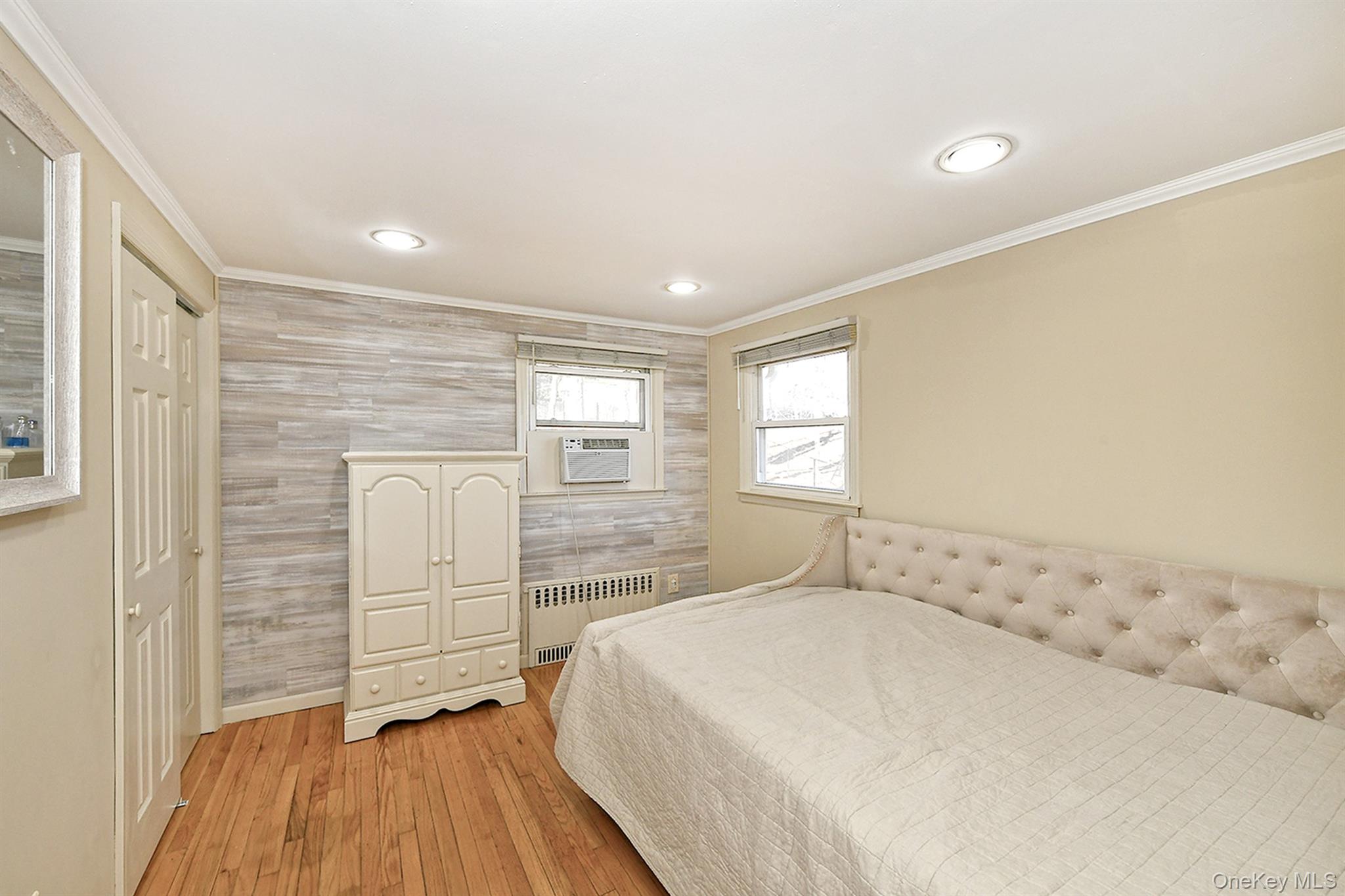 150 Hallock Landing Road Rocky Point, NY 11778 - Photo 22 of 36 Bedroom featuring hardwood / wood-style floors, crown molding, radiator heating unit, recessed lighting, and a closet