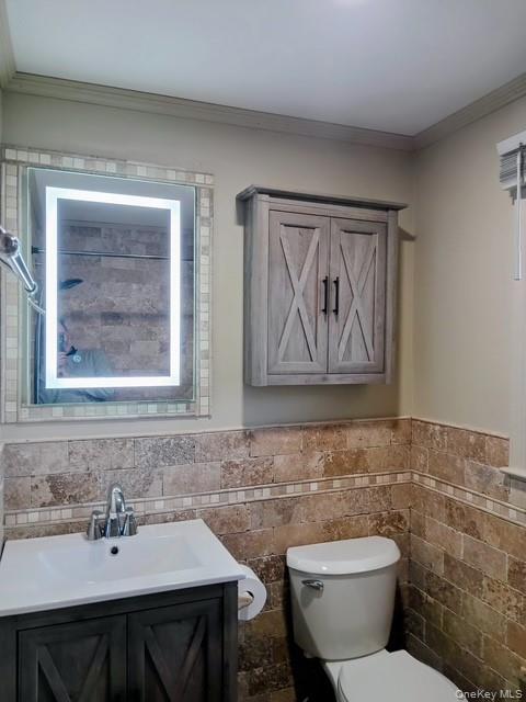 150 Hallock Landing Road Rocky Point, NY 11778 - Photo 23 of 36 Bathroom with vanity, wainscoting, tile walls, and crown molding
