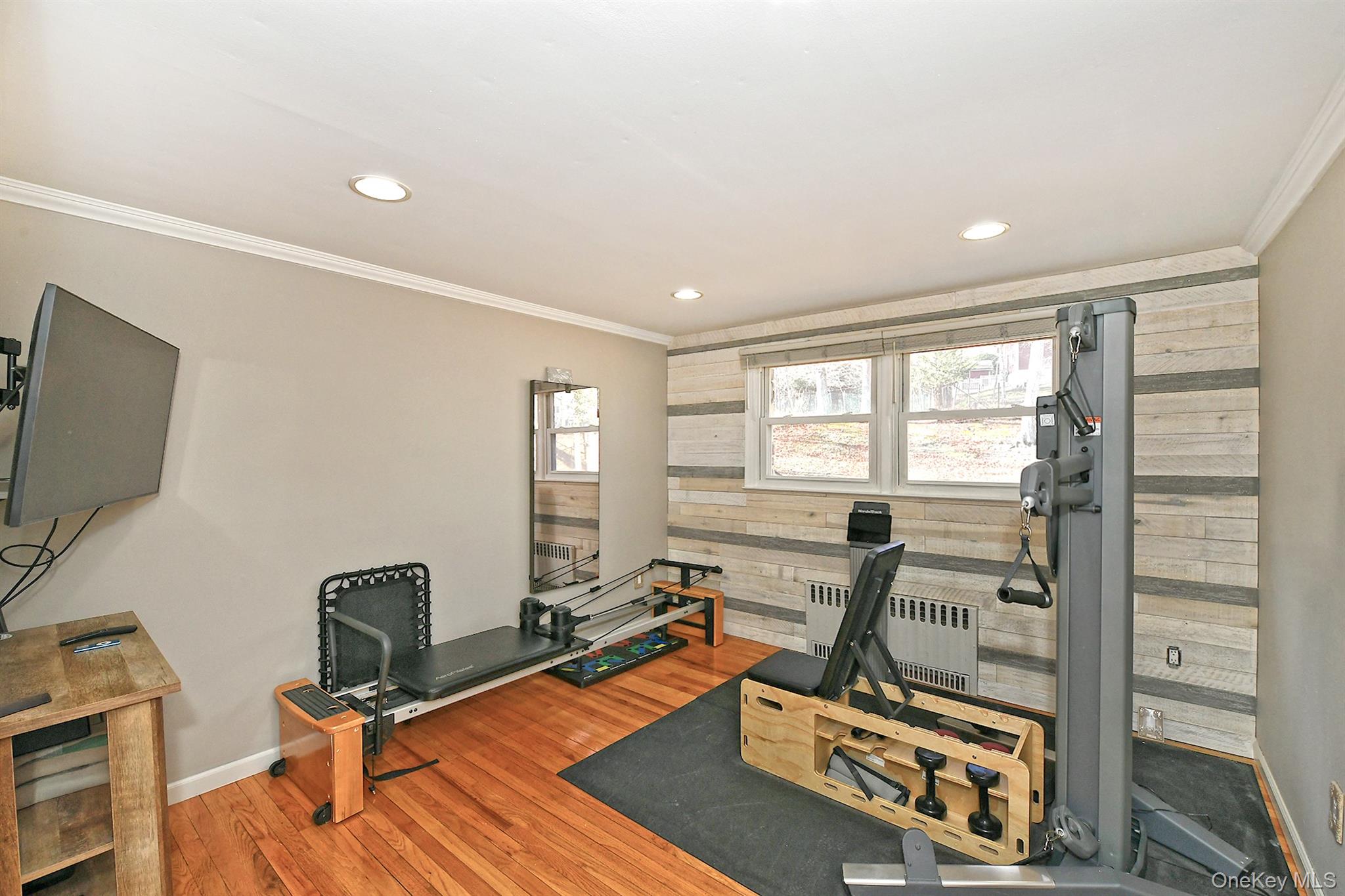 150 Hallock Landing Road Rocky Point, NY 11778 - Photo 24 of 36 Exercise room featuring wooden walls, radiator heating unit, crown molding, wood finished floors, and recessed lighting