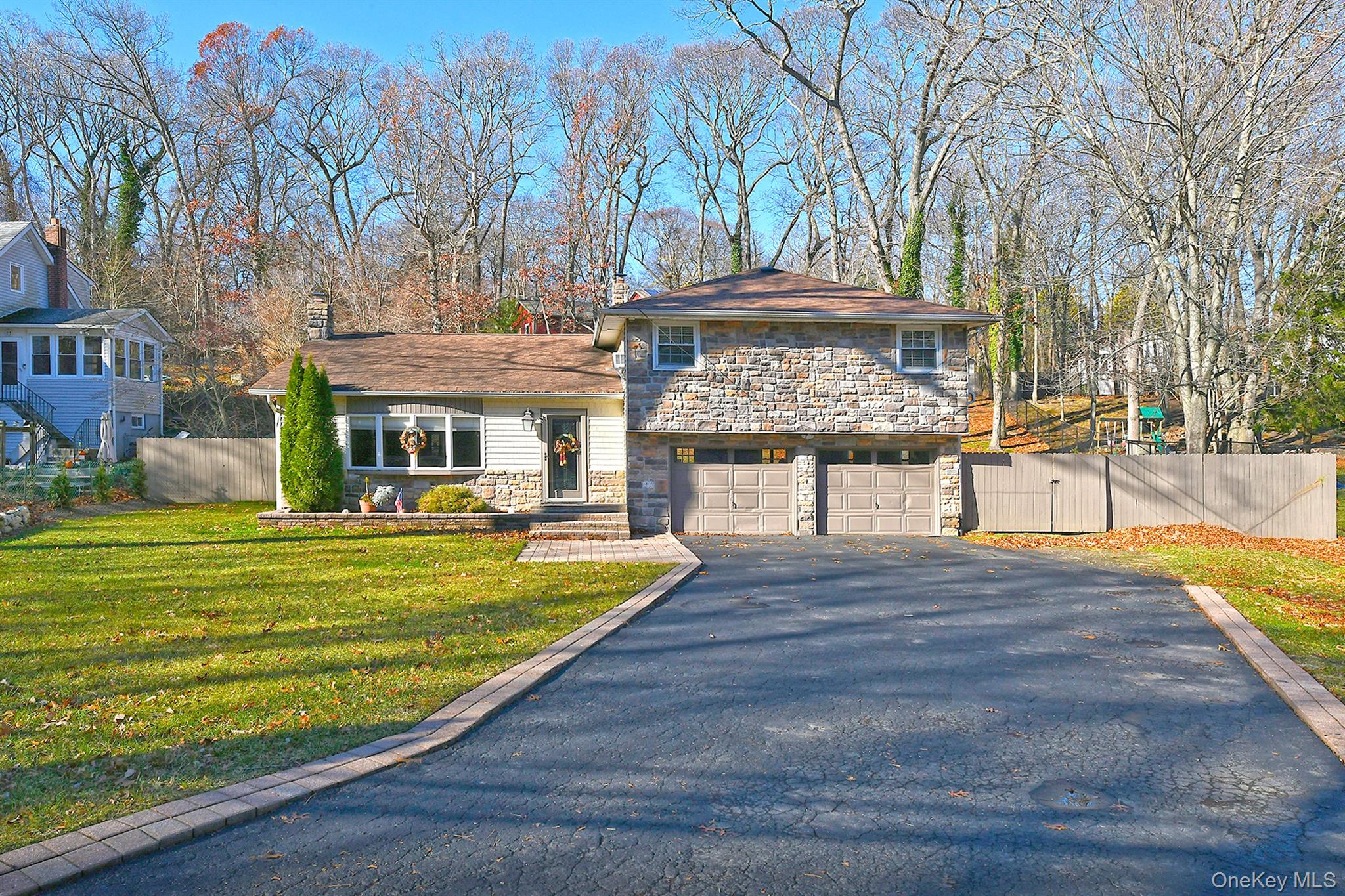 150 Hallock Landing Road Rocky Point, NY 11778 - Photo 4 of 36 Split level home with stone siding, asphalt driveway, a garage, and a gate