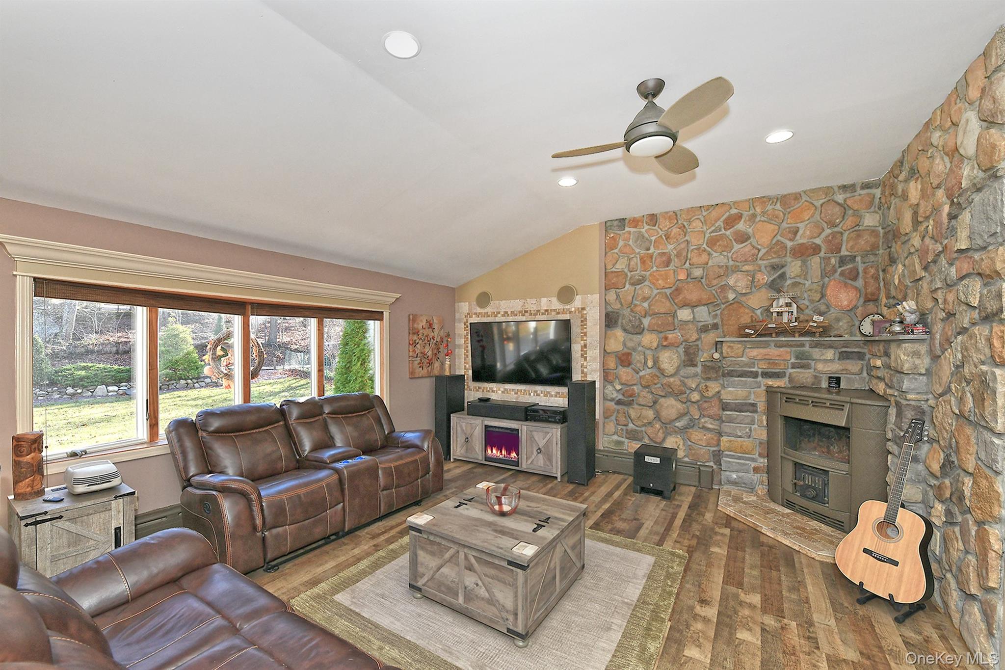 150 Hallock Landing Road Rocky Point, NY 11778 - Photo 9 of 36 Living area with vaulted ceiling, a warm lit fireplace, hardwood / wood-style floors, a ceiling fan, and recessed lighting