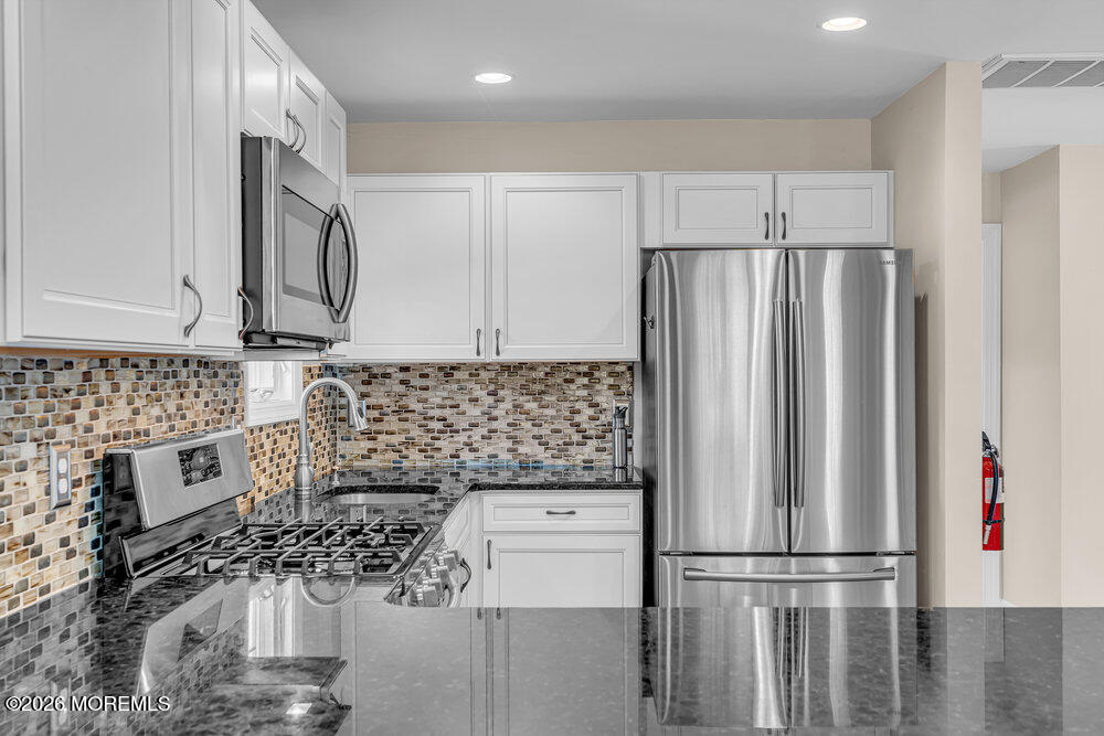 1407 Edgemere Road Wall, NJ 07719 - Photo 3 of 17 a kitchen with stainless steel appliances granite countertop a refrigerator and a stove