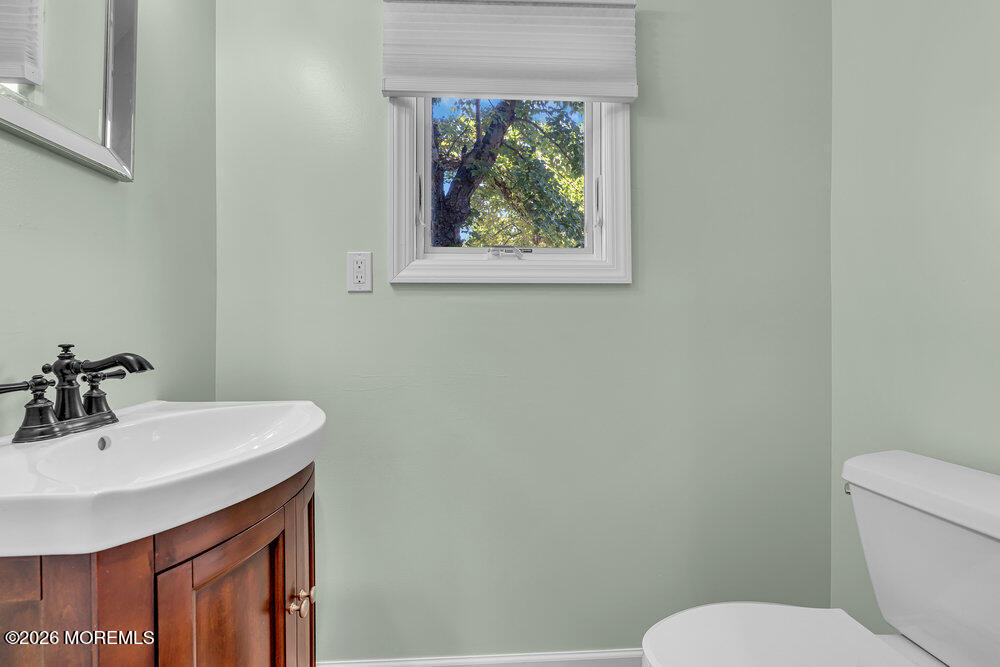 1407 Edgemere Road Wall, NJ 07719 - Photo 9 of 17 a bathroom with a toilet a sink and mirror